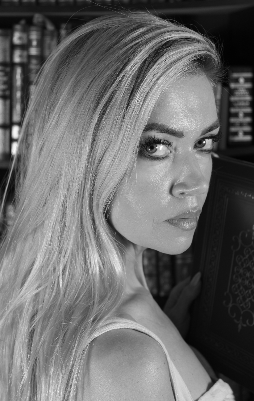 black and white photo headshot of female in front of a bookcase