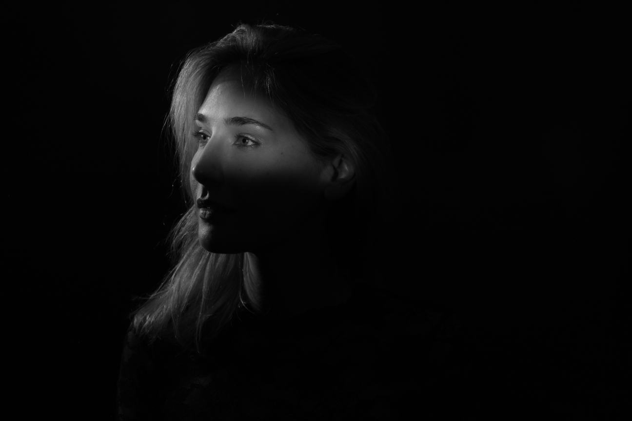 black and white head shot of female with strong key light