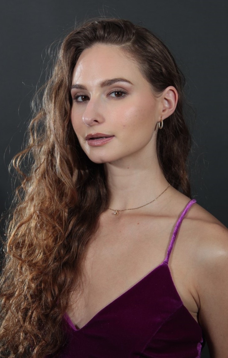 long haired brunette female in purple dress
