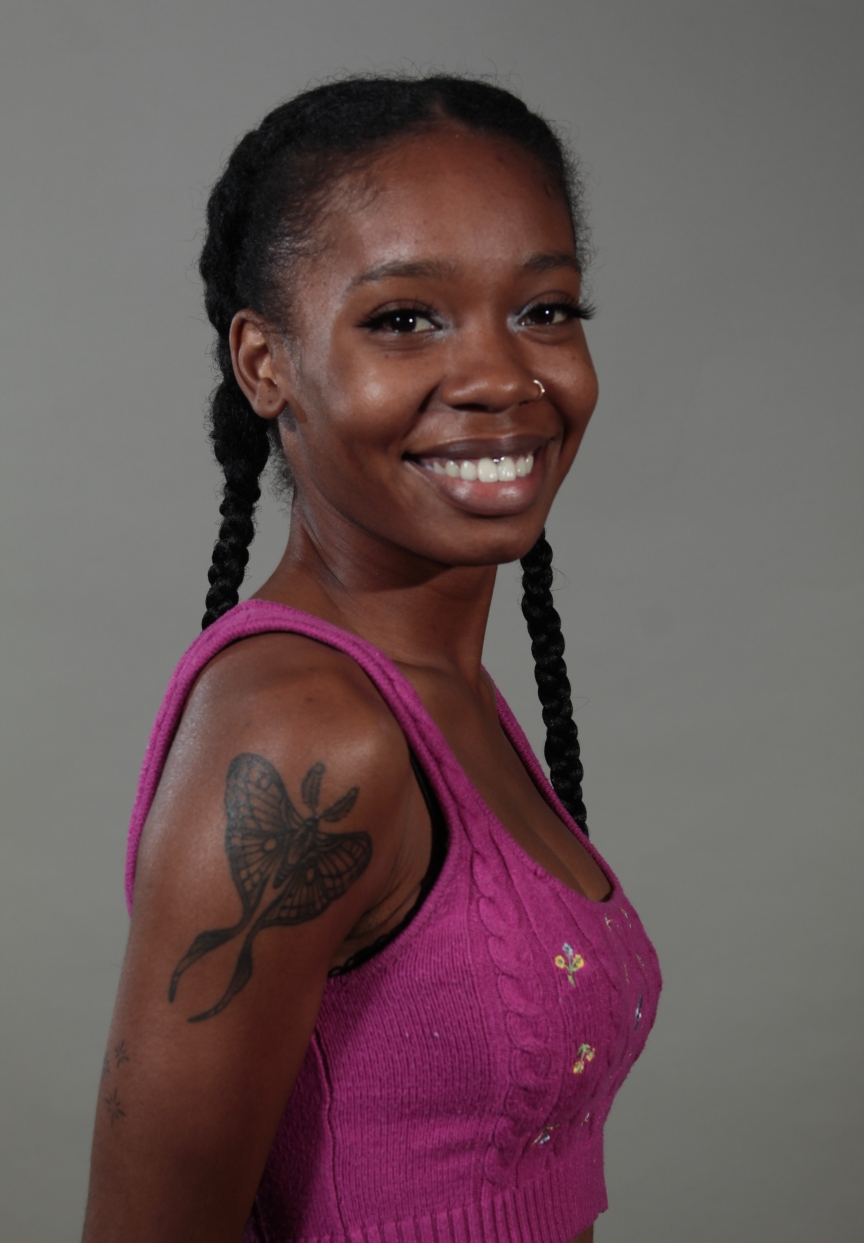 female in pink top against a gray background