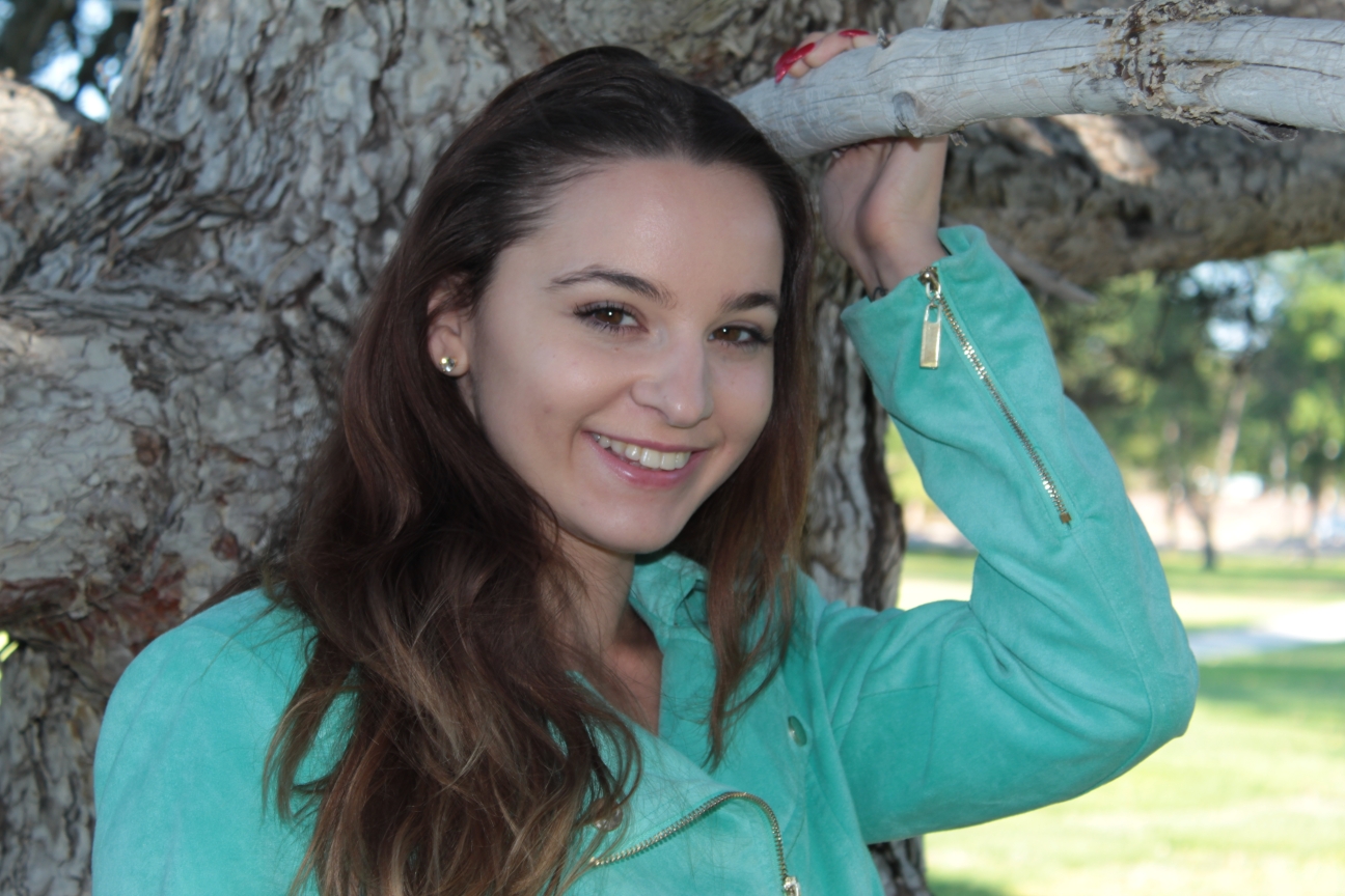 head shot of female by a pine tree in the park