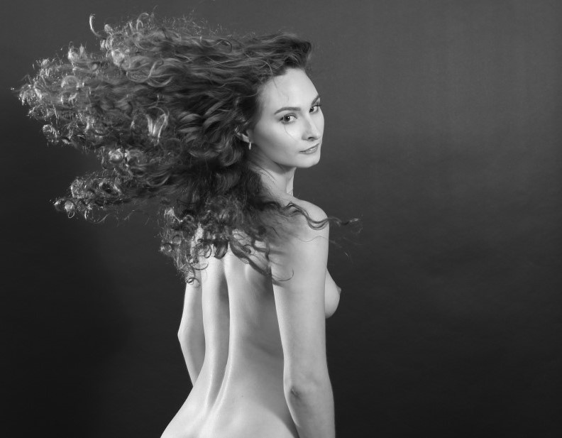 profile of nude female doing a hair flip