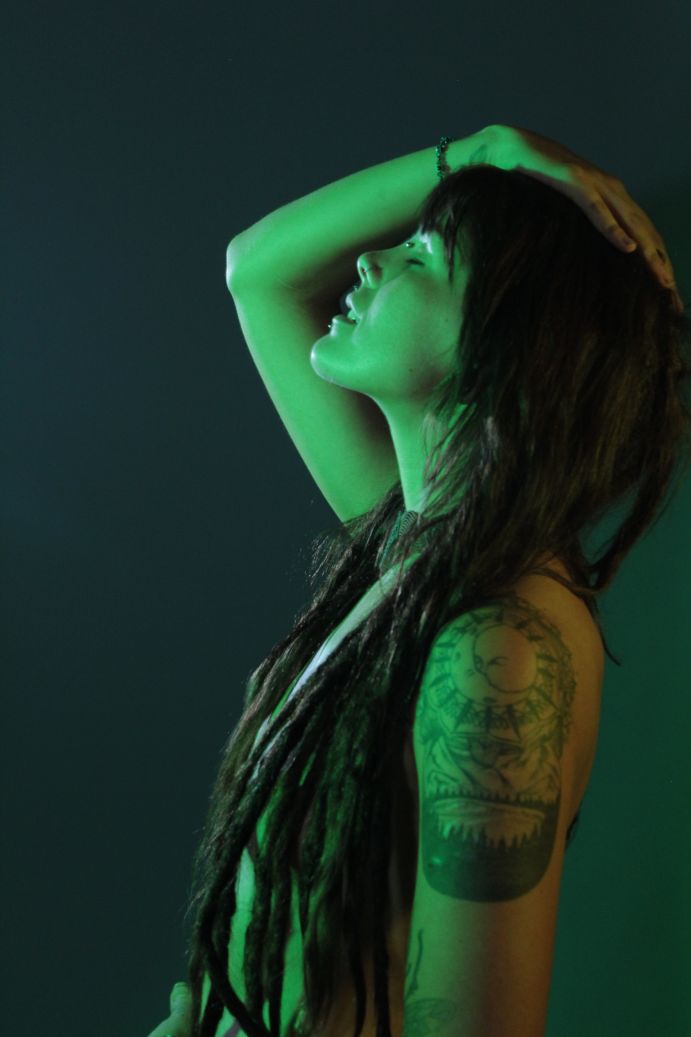 Topless woman profile with green and yellow lighting