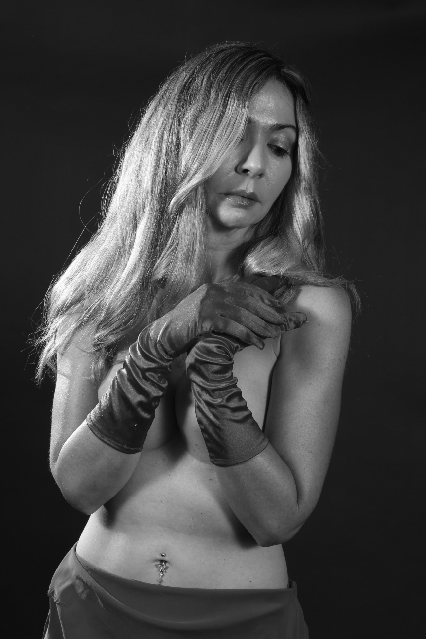 black and white image of topless woman wearing long gloves